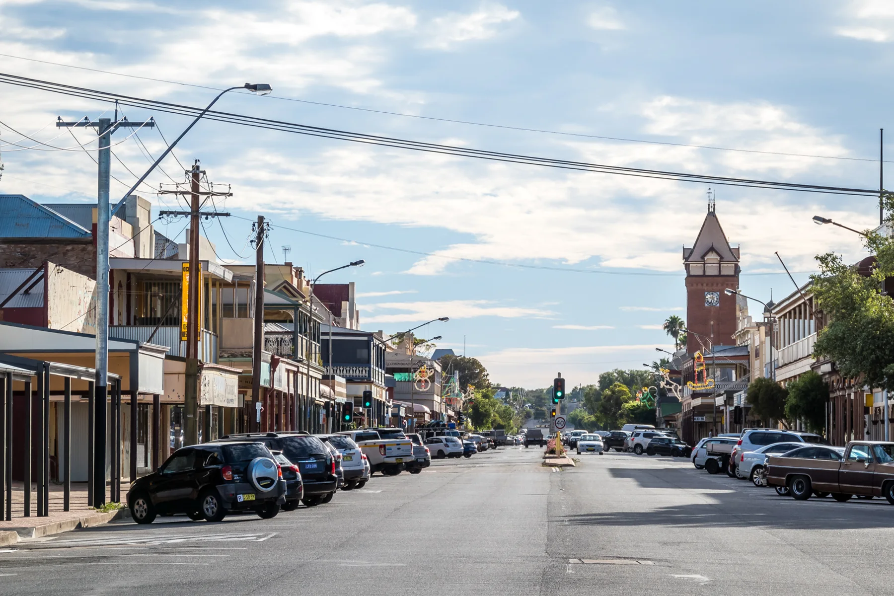 A contemporary view along Argent Street in Broken Hill with parked vehicles and the town clock tower