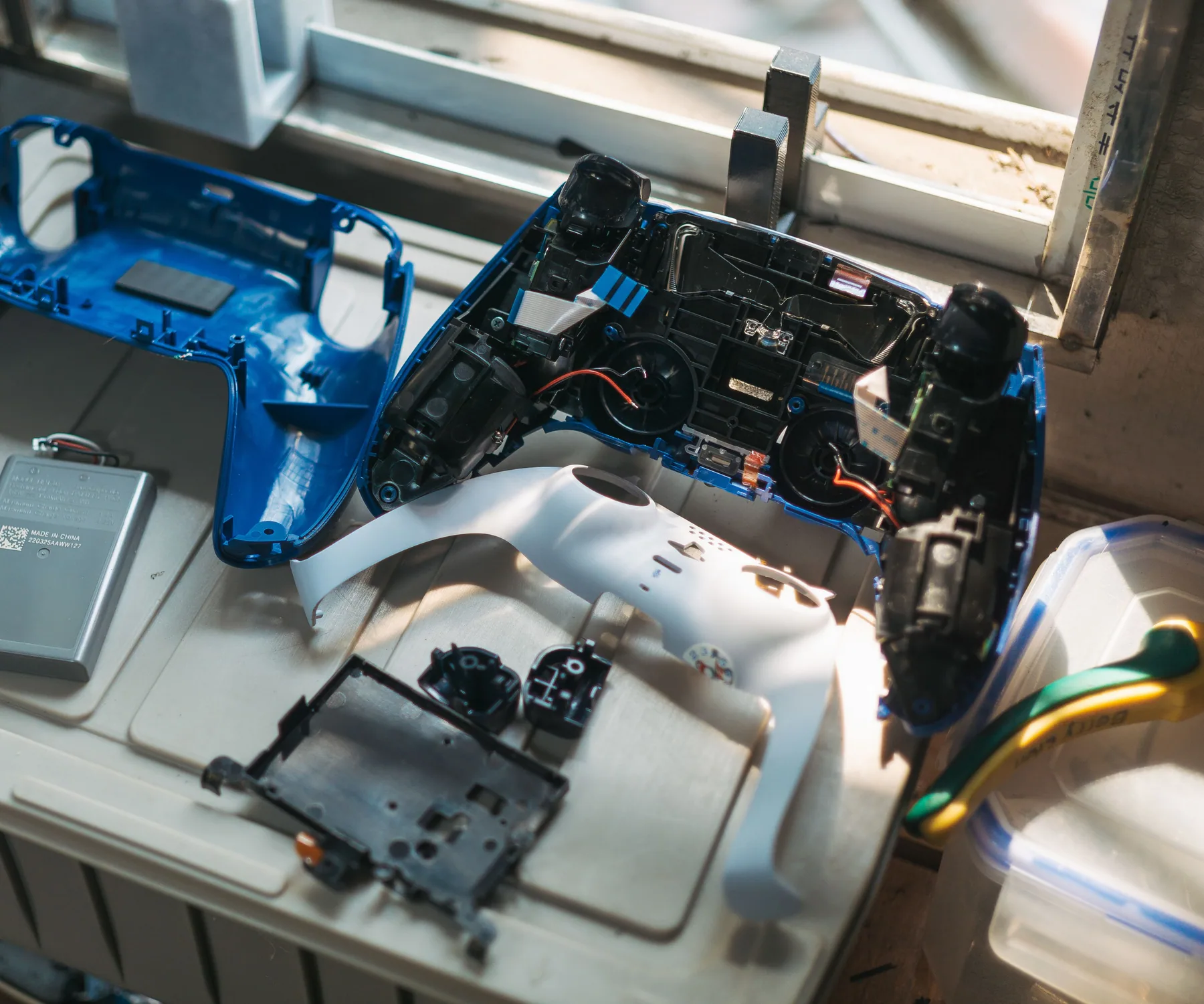 Disassembled game controllers and parts arranged on a repair workbench